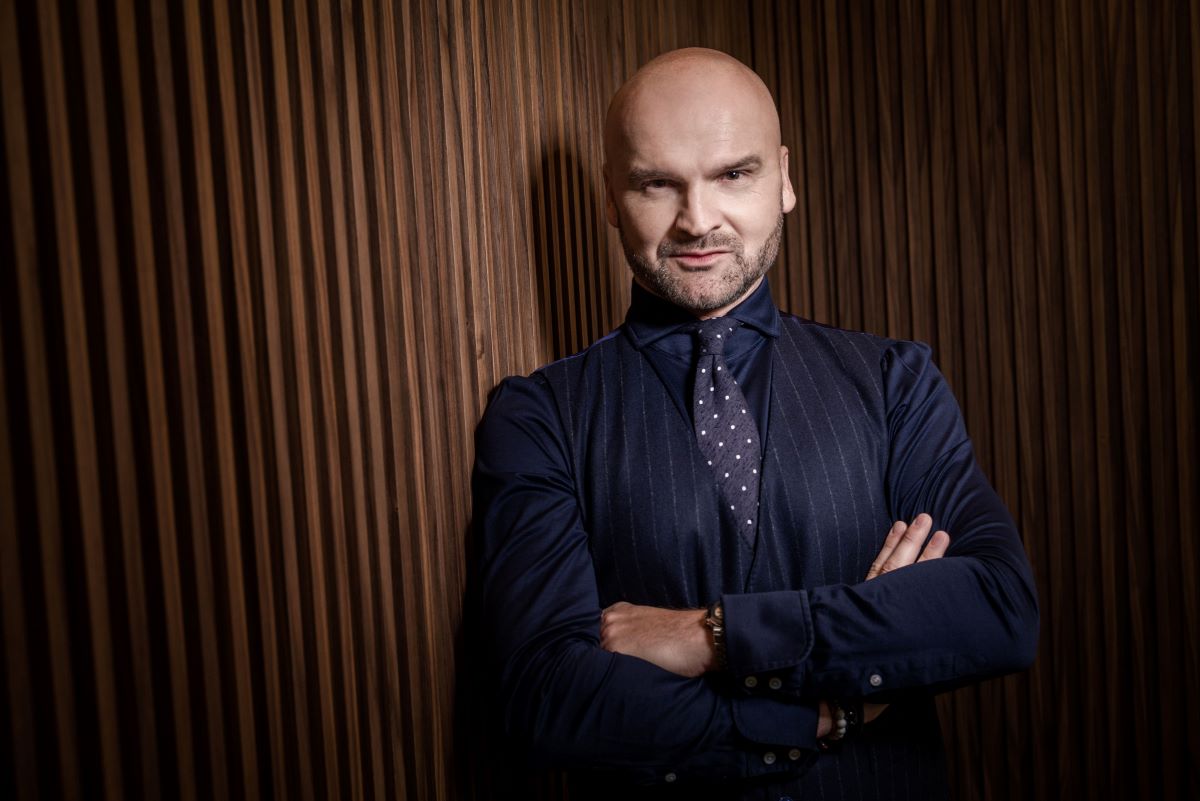 InPost uruchomił usługę dostaw międzynarodowych, która obsługiwana jest na podobnej zasadzie, co przesyłki krajowe. To rewolucja, dzięki której paczka wysłana z osiedlowego paczkomatu transportowana jest bezpośrednio do jej odbiorcy mieszkającego za granicą. Nowa usługa polskiego operatora to również możliwość nadawania bagaży, których nie uwzględnia twój bilet lotniczy. Przesyłki międzynarodowe InPostu – przyjrzeliśmy się szczegółom innowacyjnej oferty. Prezes InPostu. Mężczyzna w średnim wieku z kilkudniowym, zadbanym zarostem. Ma on na sobie granatową koszulę, fioletowy krawat w białe kropki oraz granatową kamizelkę w białe, pionowe paski. Na zdjęciu Rafał Brzoska ma założone ręce. Na jego lewym nadgarstku znajduje się złoty zegarek.