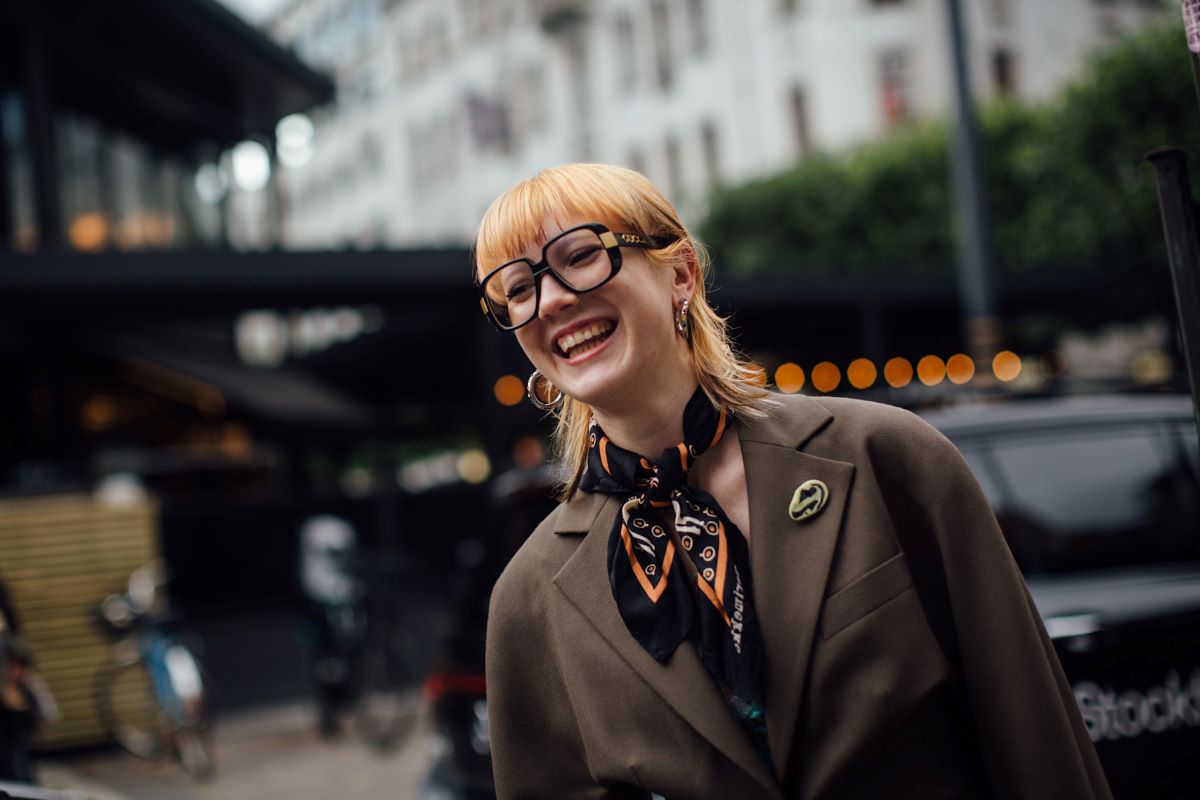 Kurz po Czarnym Piątku jeszcze nie opadł, a firmy analityczne już informują o wartościach koszyków zakupowych konsumentów z całego świata. Czy tegoroczne święto promocji było okresem rekordowej sprzedaży? A może niepewność gospodarcza oraz unijna dyrektywa Omnibus zahamowały rosnący konsumpcjonizm. Sprawdziliśmy, ile Polacy wydali w Black Friday. Uśmiechnięta kobieta o rudych włosach stoi na ulicy w okresie Black Friday 2024. Ma na sobie brązową marynarkę, jej szyję przyozdabia kolorowa apaszka.