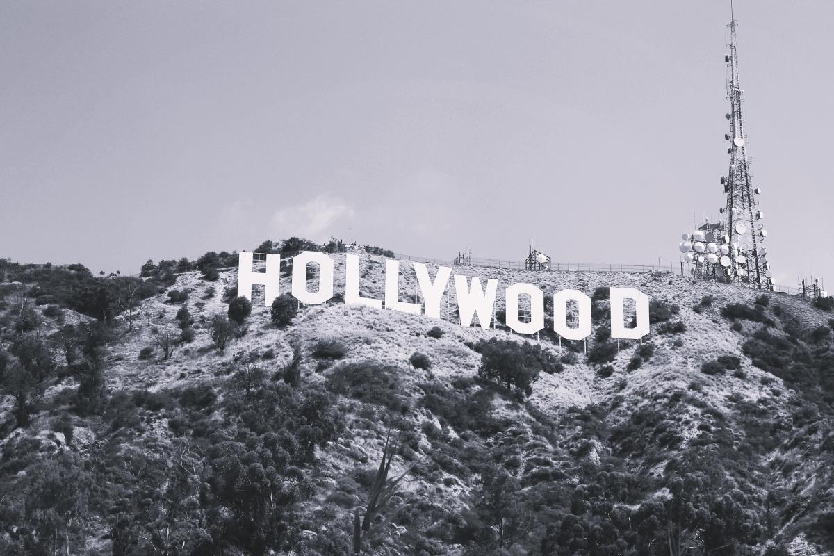 Zdjęcie przedstawia słynny znak Hollywood na wzgórzach Los Angeles, symbol światowego przemysłu rozrywkowego. W obliczu trwających pożarów w Los Angeles sceneria ta nabiera dramatycznego znaczenia, przypominając o zagrożeniu dla miasta oraz wpływie katastrofy na lokalną społeczność i kluczowe branże, takie jak moda i film.