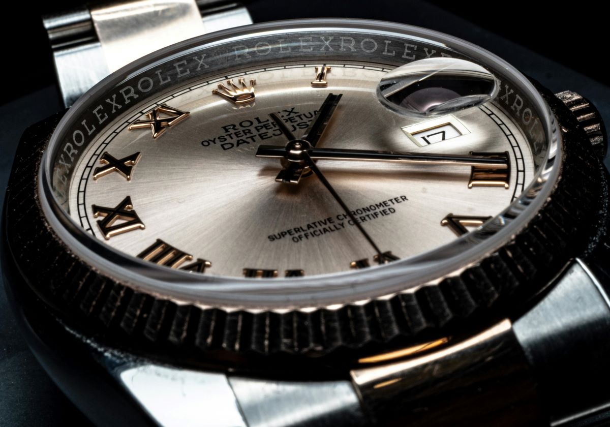 Zdjęcie przedstawia luksusowy zegarek Rolex Oyster Perpetual Datejust z widoczną tarczą, rzymskimi indeksami oraz charakterystycznym powiększającym okienkiem daty. Symbol elegancji i precyzji, odzwierciedla tematykę dotyczącą spadających cen luksusowych zegarków w 2024 roku.