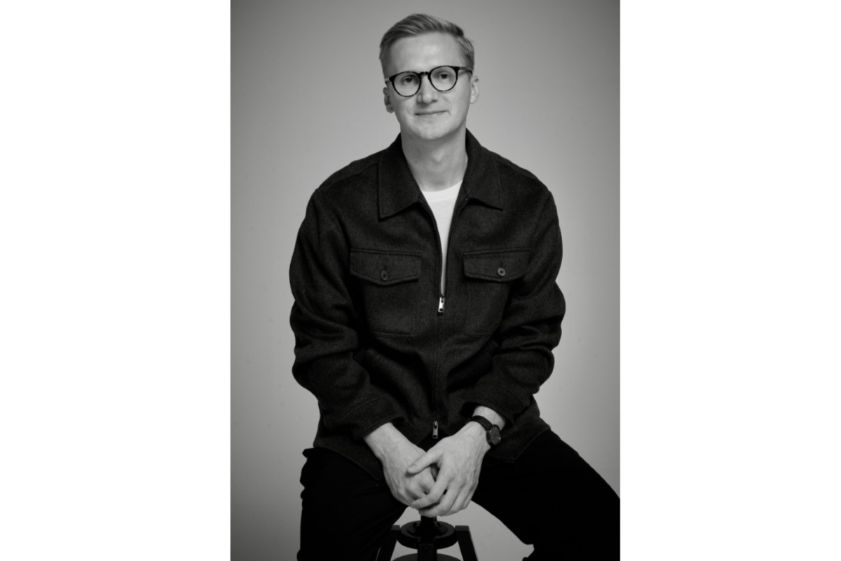 Ostatnie miesiące były dla marki PRM okresem wzmożonego rozwoju, popartego inwestycjami oraz systematyczną realizacją długofalowej strategii marketingowej. W rozmowie z Fashion Biznesem dyrektor PRM, Kamil Bajołek, oraz dyrektorka marketingu należącego do Answear.com brandu, Kaja Wrzeszcz, opowiedzieli między innymi o przepisie na poprawę wyników finansowych, zagranicznej ekspansji i planowanych kampaniach. Czarno białe zdjęcie. Dyrektor marki PRM, Kamil Bajołek, w portretowej kompozycji. Mężczyzna ma krótkie włosy. Na jego twarzy widoczne są okulary o klasycznym, ponadczasowym kształcie. Ubrany jest on w czarne spodnie i ciemną koszulę.