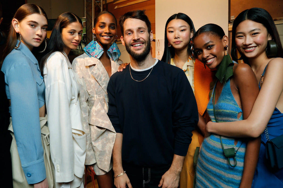 L'Oreal inwestuje w dom mody Jacquemus. Wspólnie stworzą linię kosmetyków. Na zdjęciu Simon Porte Jacquemus w otoczeniu modelek na backstage pokazu.