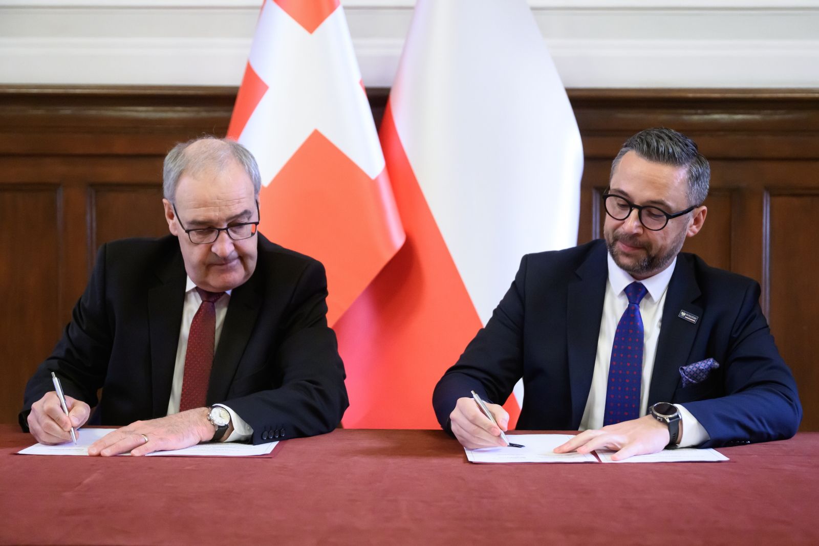 Poznań, 15.05.2025. Minister nauki i szkolnictwa wyższego Marcin Kulasek (C), radca federalny Szwajcarii Guy Parmelin (CL) i rektor Uniwersytetu im. Adama Mickiewicza prof. dr hab. Bogumiła Kaniewska (CP) podczas podpisywania memorandum o porozumieniu w dziedzinie badań naukowych i innowacji ze Szwajcarią, 15. tego miesiąca na Uniwersytecie im. Adama Mickiewicza w Poznaniu. PAP/Jakub Kaczmarczyk 1