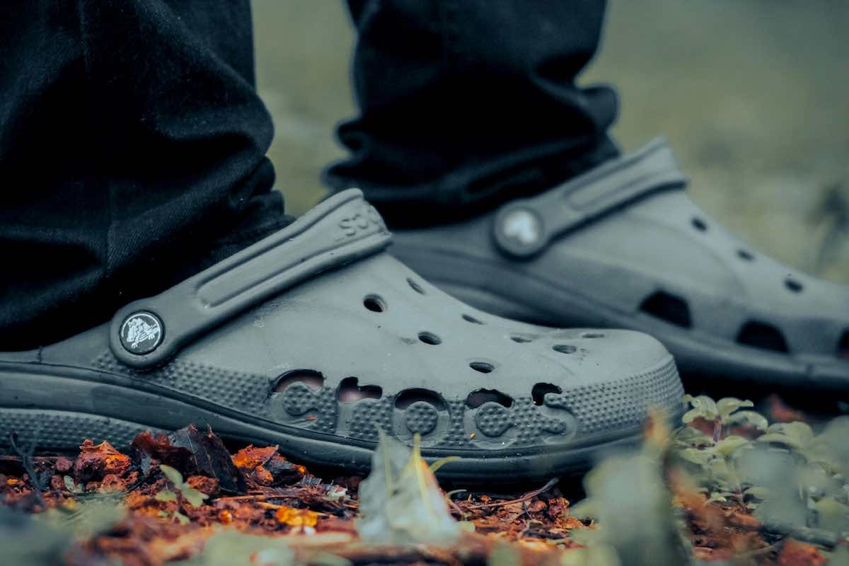 Crocs notuje ogromny spadek na giełdzie. Zdjęcie przedstawia zbliżenie Crocsów na nogach.
