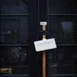 Bankructwo w domu. Czy znana firma ogłosi upadłość? Zdjęcie zamkniętych czarnych drzwi z napisem
