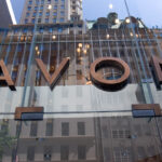 Avon ogłasza redukcję zatrudnienia. Na zdjęciu logo Avon na lustrzanej fasadzie biura.