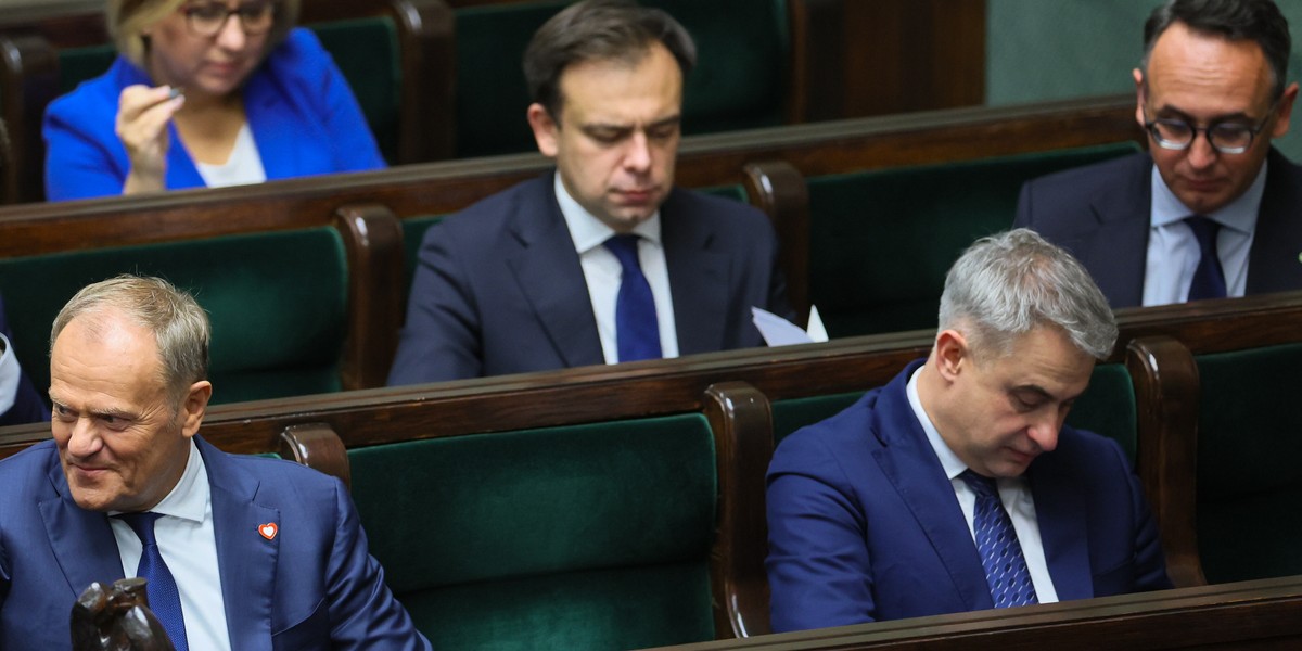 Minister Andrzej Domański w otoczeniu innych ministrów i Premiera w Sejmie.