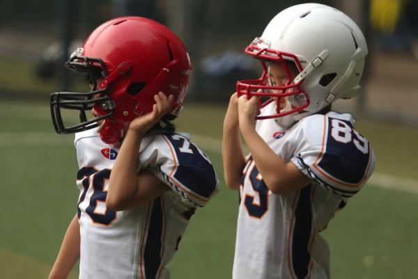 Young boys wear pads and helmets as they take part in a football camp with former NFL players in Beijing in 2018. An NIH study evaluated the brains of athletes in contact sports under the age of 51 and found signs of neuron loss well before the typical signs of CTE. File Photo by Stephen Shaver/UPI