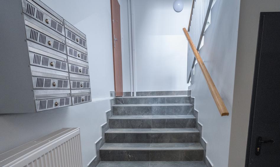 Spółdzielnie mieszkaniowe od dawna stanowią powszechny model zarządzania nieruchomościami w Polsce. W ramach tych struktur właściciele lokali nie tylko zajmują swoje prywatne mieszkania, ale także korzystają ze wspólnych przestrzeni – klatek schodowych, wejść, wind, komórek lokatorskich i terenów zewnętrznych. Takie wspólne strefy wymagają stałego utrzymania, finansowanego ze składek zbiorowych. Ponieważ opłaty te czasami wywołują kontrowersje, specjaliści z GetHome.pl postanowili zbadać ramy prawne regulujące odpowiedzialność finansową każdego mieszkańca za utrzymanie nieruchomości. Utrzymanie części wspólnych i czynsz w mieszkaniach wielorodzinnych – jaki jest między nimi związek?