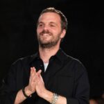 Matthieu Blazy na wydarzeniu Bottega Veneta, stojący na tle ciemnego tła