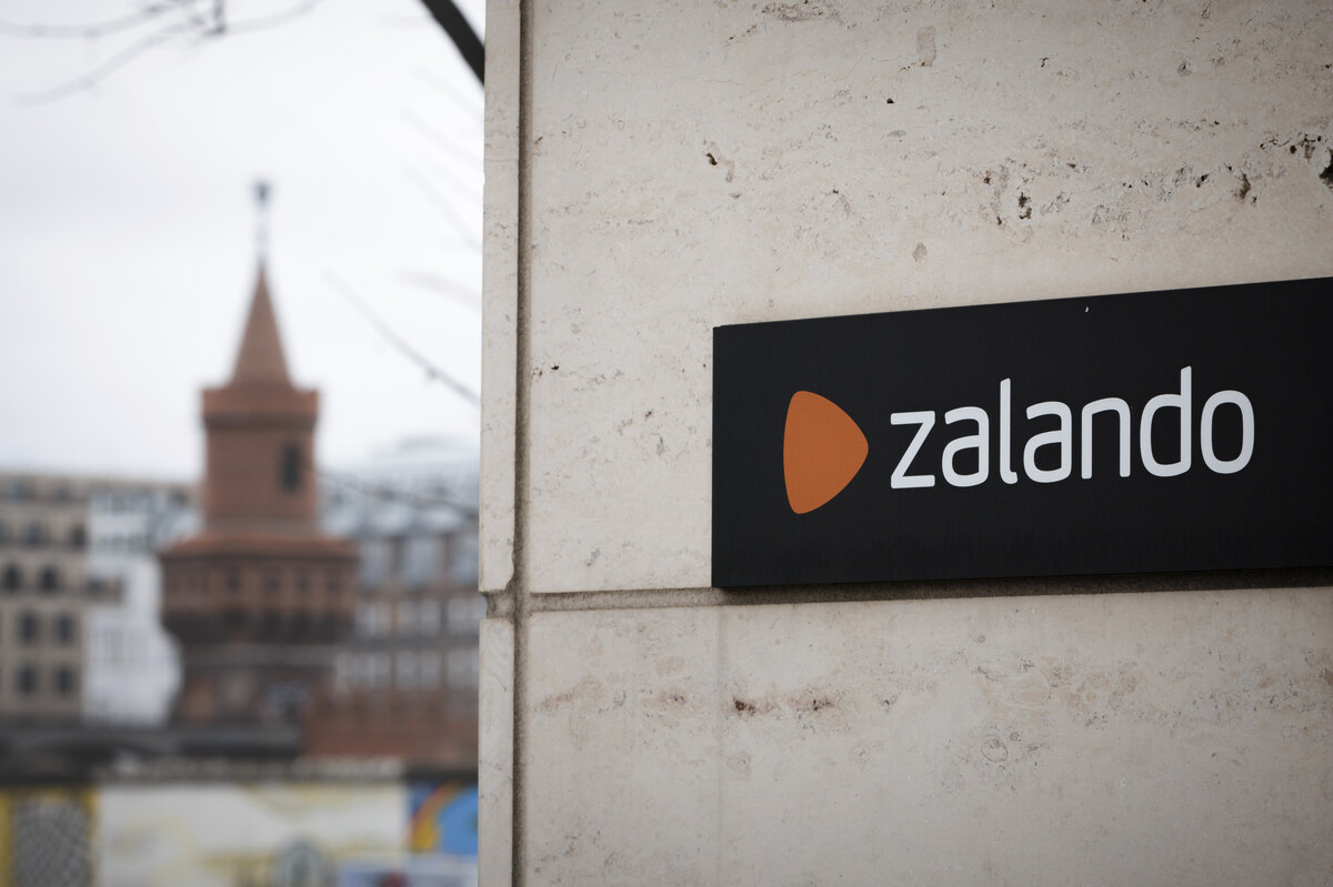 Sąd UE wydał orzeczenie w sprawie sporu Zalando z Komisją Europejską. Firma, której nazwa widnieje na czarnym szyldzie na zdjęciu, nadal jest zarejestrowana jako VLOP. Na zdjęciu widać budynek z bliska, z rozmytym krajobrazem miejskim w tle.