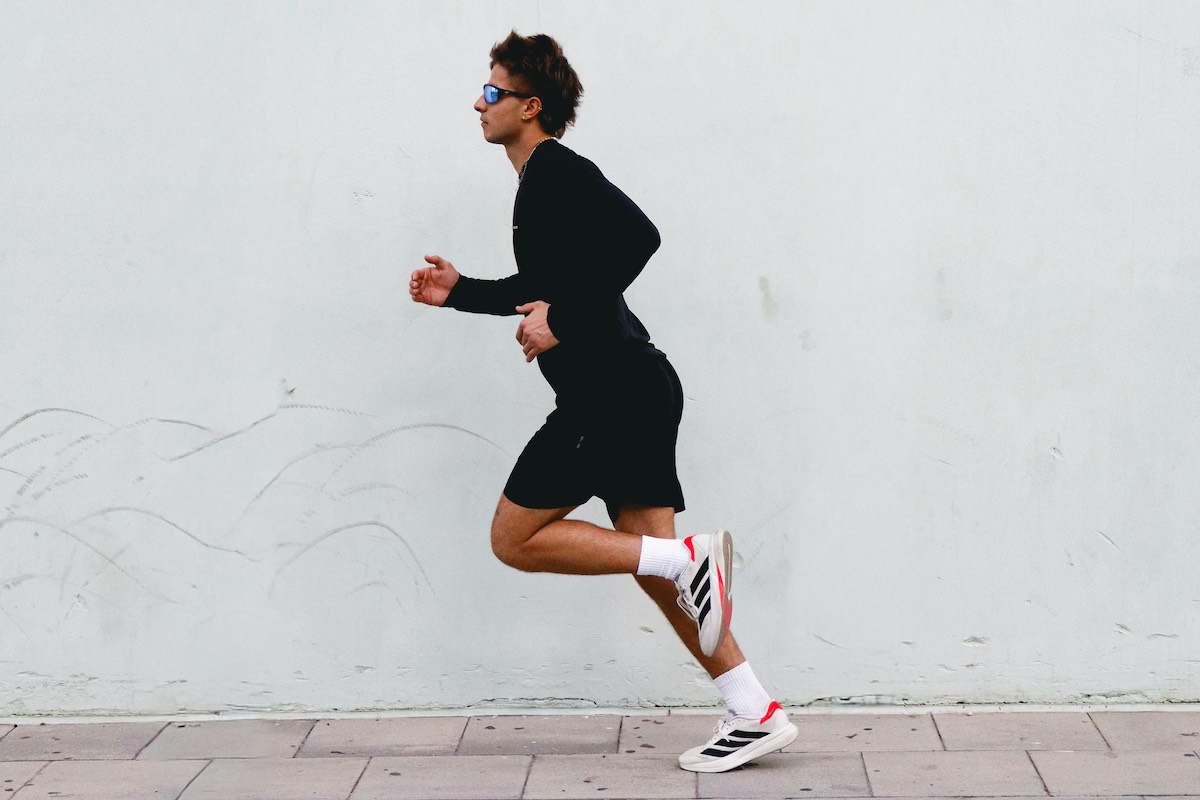 Mocny skok sprzedaży, większe dochody oraz powrót do korzeni. Adidas, niemiecki potentat sportowy, nie przestaje budować na nowo swojej pozycji na arenie globalnej mody i sportu. Adidas wyniki finansowe Q3 2025. Na zdjęciu biegacz w butach do biegania Adidas