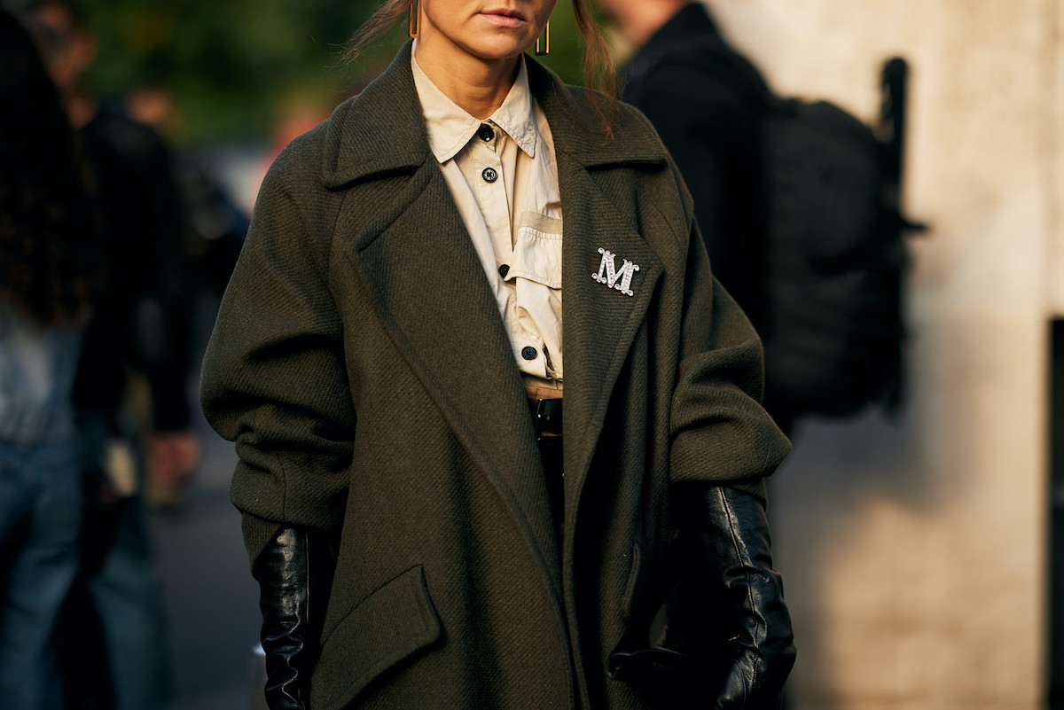 Nowe zarządzenie Ministerstwa Finansów traktuje przewóz odzieży i obuwia analogicznie do transportu materiałów pędnych lub trunków. Począwszy od marca 2026 roku każda partia przekraczająca 10 kilogramów odzieży lub 20 par obuwia będzie musiała być zarejestrowana w systemie SENT. Specjaliści z sektora alarmują: to działanie, które może opóźnić obrót i podwyższyć wydatki prowadzenia działalności gospodarczej. Branża modowa pod kontrolą. Od 2026 r. SENT obejmie ubrania i buty. Na zdjęciu zbliżenie na modelkę w koszuli i płaszczu.