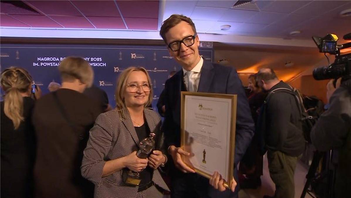 Kobieta i mężczyzna odbierają nagrodę za reportaż o Powstaniu Warszawskim.