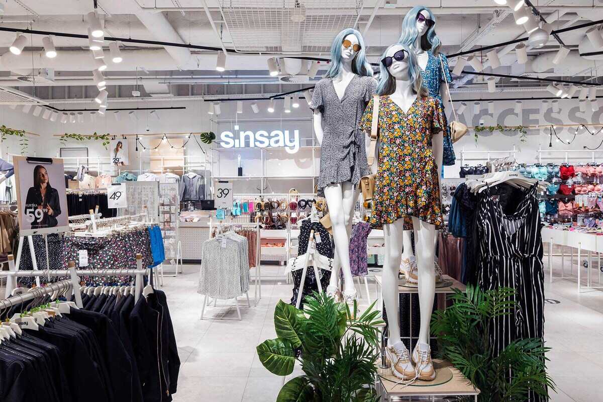 LPP nie spowalnia. Ze wstępnych informacji opublikowanych przez korporację, przytaczanych przez PAP Biznes, wynika, iż w trzecim kwartale 2025 roku (sierpień-październik) grupa uzyskała 23-procentową zwyżkę dochodów rok do roku w walutach stałych. Dla polskiego potentata w branży mody to sygnał, że wybrana taktyka przynosi pożądane efekty. Wstępne dane operacyjne LPP za trzeci kwartał 2025 roku. Wnętrze jasnego sklepu odzieżowego Sinsay z manekinami w letnich, kwiecistych sukienkach i ciemnych okularach przeciwsłonecznych na pierwszym planie, otoczonymi wieszakami pełnymi ubrań i akcesoriów, w tle widnieje neonowe logo marki.