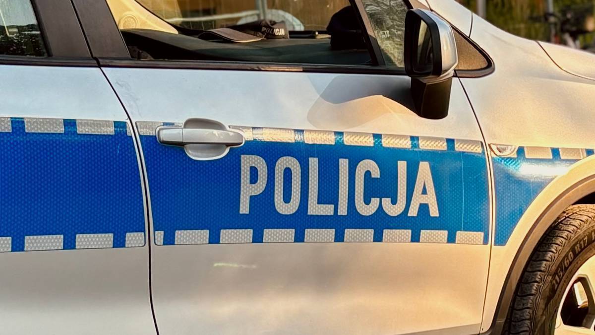Fragment samochodu policyjnego z napisem POLICJA