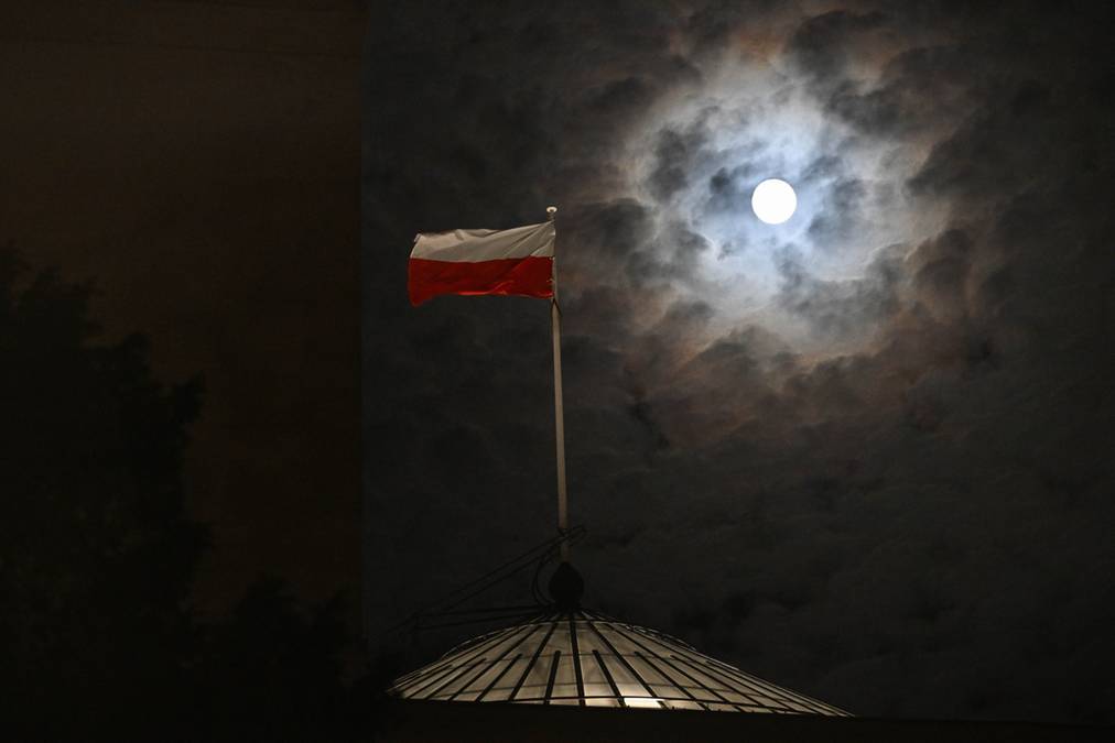 Superpełnia Księżyca widziana nad Sejmem w Warszawie Superpełnia Księżyca nad nocnym niebem w Przemyślu z polską flagą