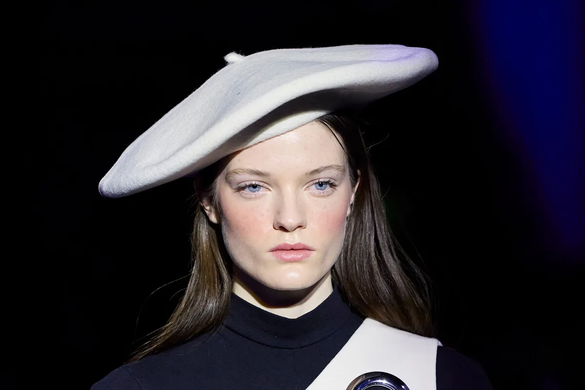 Pierre Cardin – sklep internetowy. Modelka eksponuje nowatorską stylizację Pierre Cardin na podium, z charakterystycznym, geometrycznym nakryciem głowy i minimalistyczną linią. Fotografia odnosi się do futurystycznej spuścizny domu mody, który po latach koncentruje się na sprzedaży w sieci i nowej strategii digitalowej. Kreacja akcentuje estetykę brandu, łączącą zbiory archiwalne z nowoczesnym podejściem do mody luksusowej.