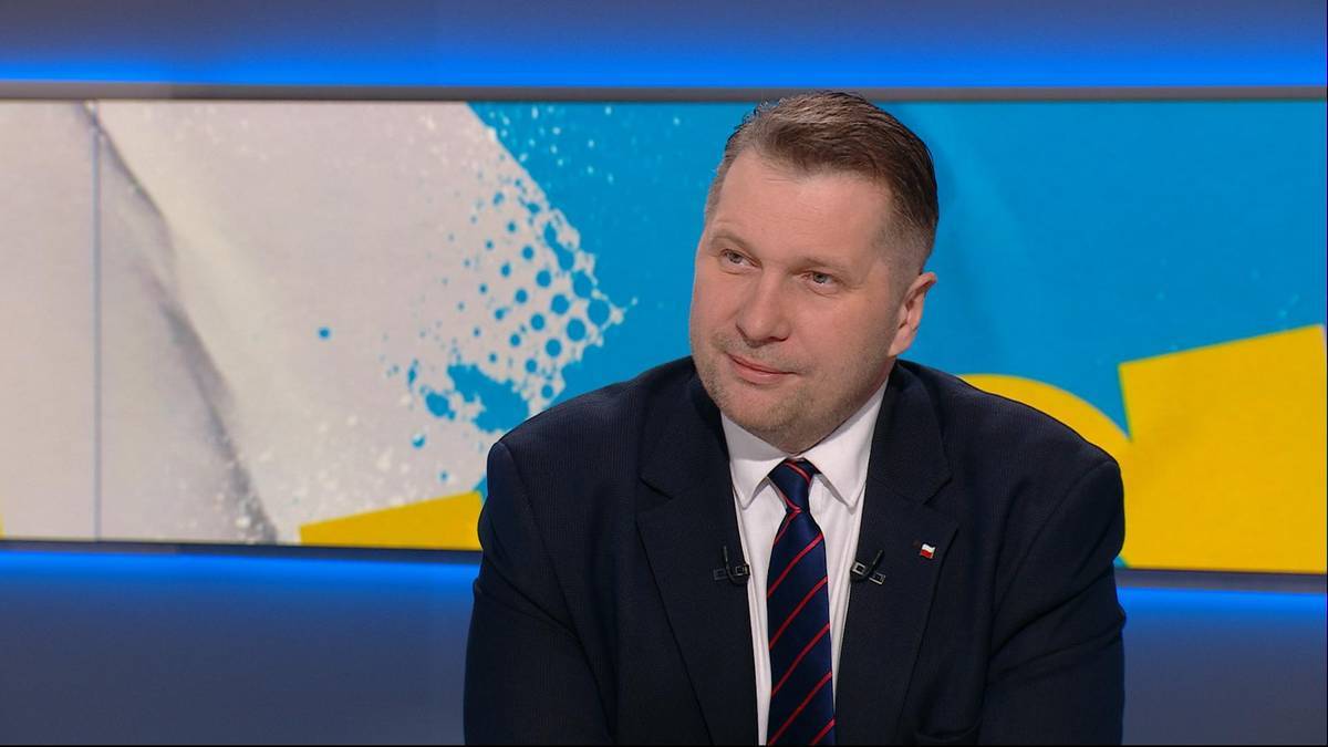 Mężczyzna w garniturze i krawacie w studiu telewizyjnym