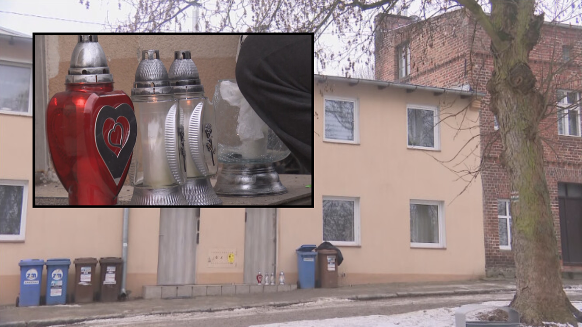 Cztery znicze, w tym jeden duży czerwony z sercem, ustawione na zewnątrz kamienicy.