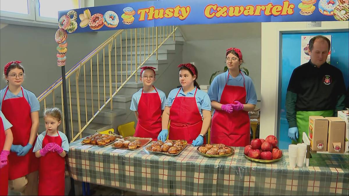 Uczestnicy kiermaszu pączk&oacute;w w szkole podstawowej, przygotowani do sprzedaży słodkości.