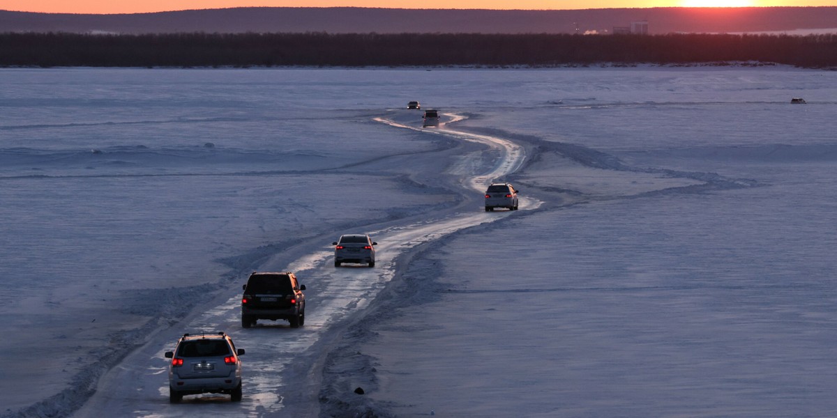 Samochody jadą zimową drogą łączącą brzegi pokrytej lodem rzeki Leny w Jakucku, 29 marca 2025 r.