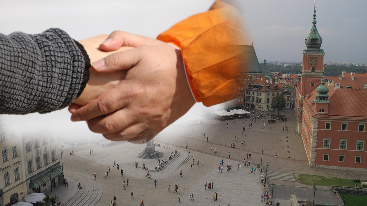 Zbliżenie na dłonie w uścisku na tle miasta.