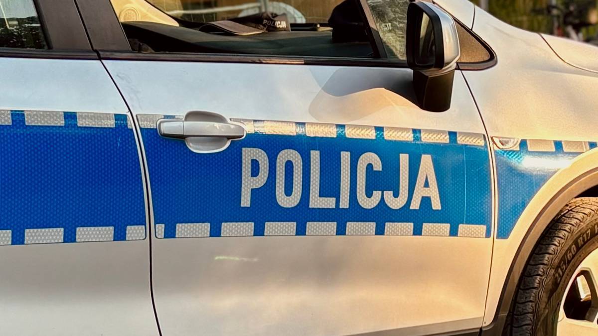 Fragment bocznej części radiowozu policyjnego z napisem "POLICJA".
