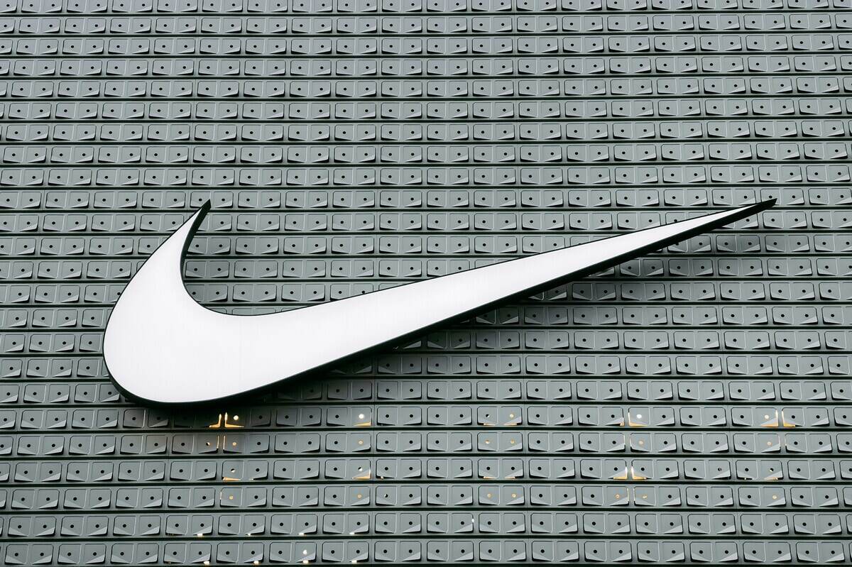 Nike dyskryminacja białych pracowników. Białe logo Nike (swoosh) zamontowane na szarej, geometrycznej elewacji budynku.