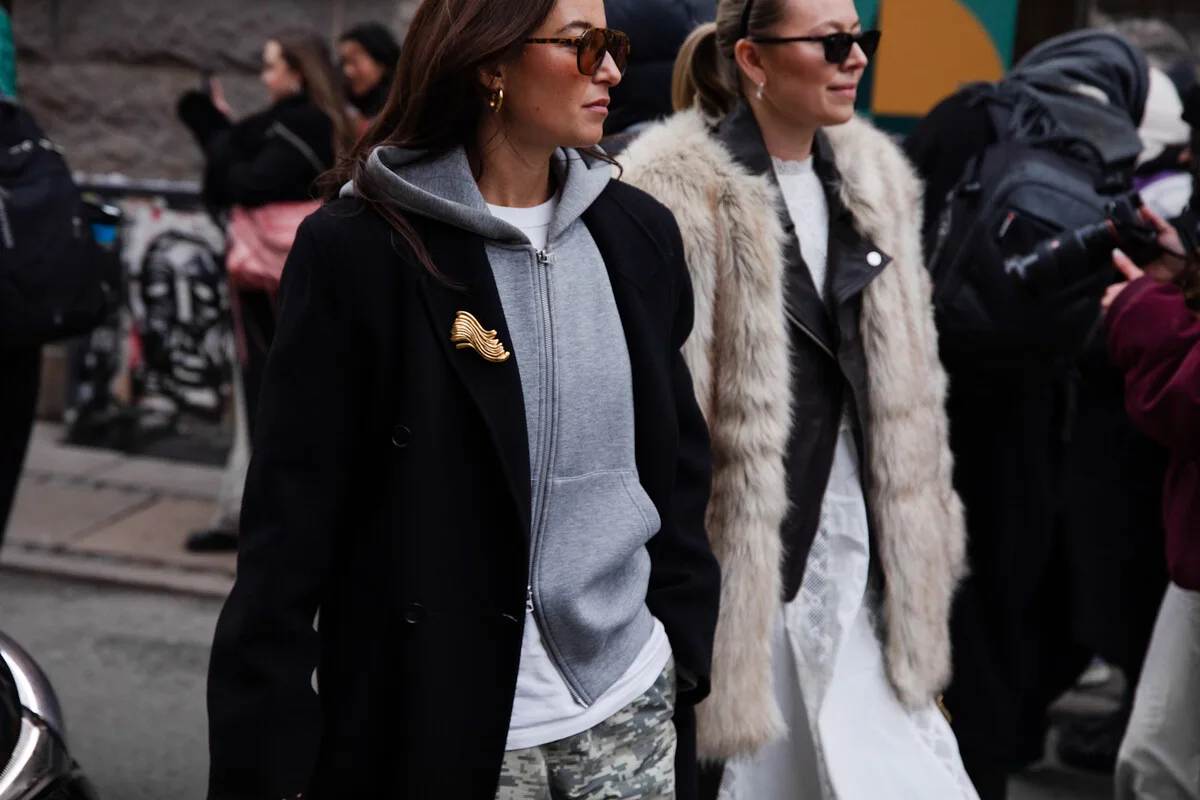 Street style podczas tygodnia mody – kobiety w warstwowych stylizacjach, łączących casual i elegancję.