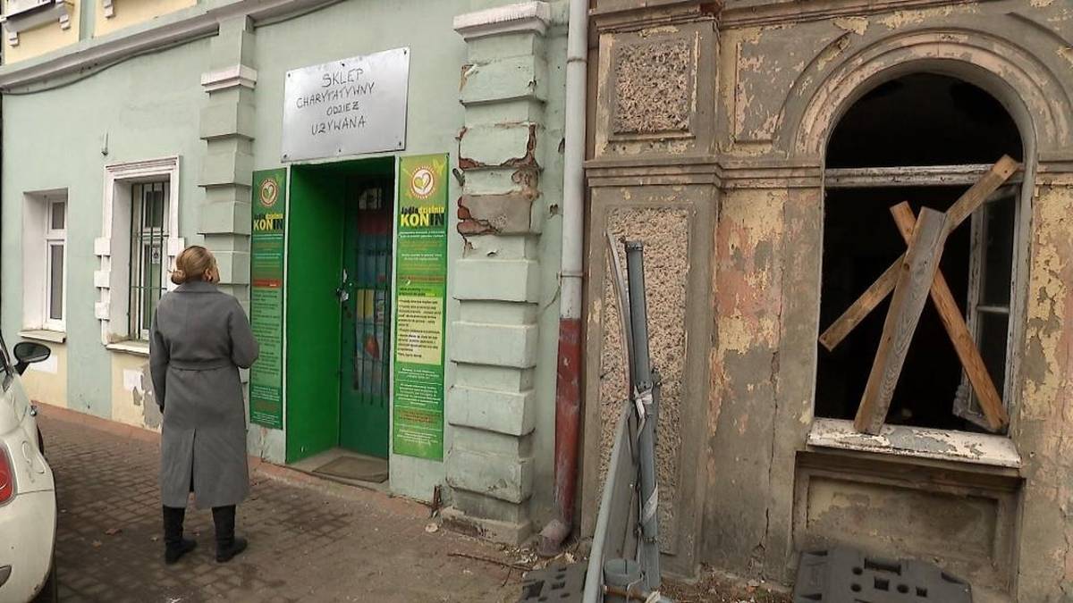 Budynek fundacji z zielonymi drzwiami i kobietą stojącą przed wejściem.