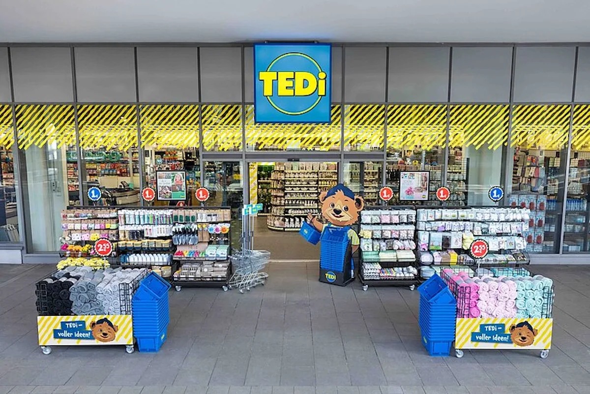 Sklep sieci TEDi – wejście do dyskontu z artykułami gospodarstwa domowego i dekoracjami, z charakterystycznym żółto-niebieskim logo oraz ekspozycją niedrogich produktów przed wejściem.