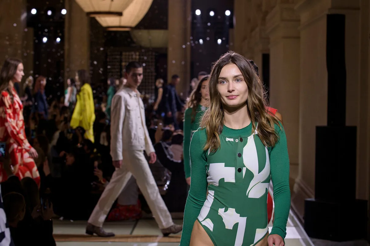 Zrównoważony rozwój H&amp;M 2025. Modelka na wybiegu podczas pokazu mody H&amp;M Group, prezentująca kolekcję w nowoczesnej przestrzeni. Fotografia odnosi się do ewolucji sektora, gdzie nawet szybka moda zaczyna łączyć stylistykę z dążeniami środowiskowymi.