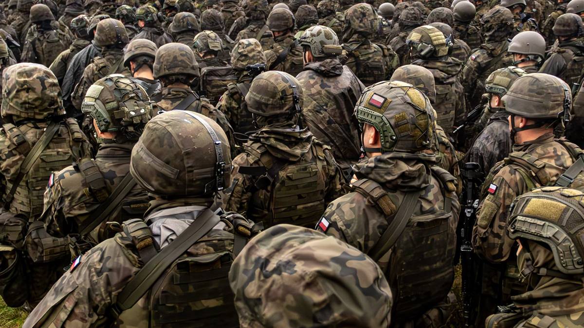 Duża grupa polskich żołnierzy w mundurach i hełmach stojąca na zewnątrz.