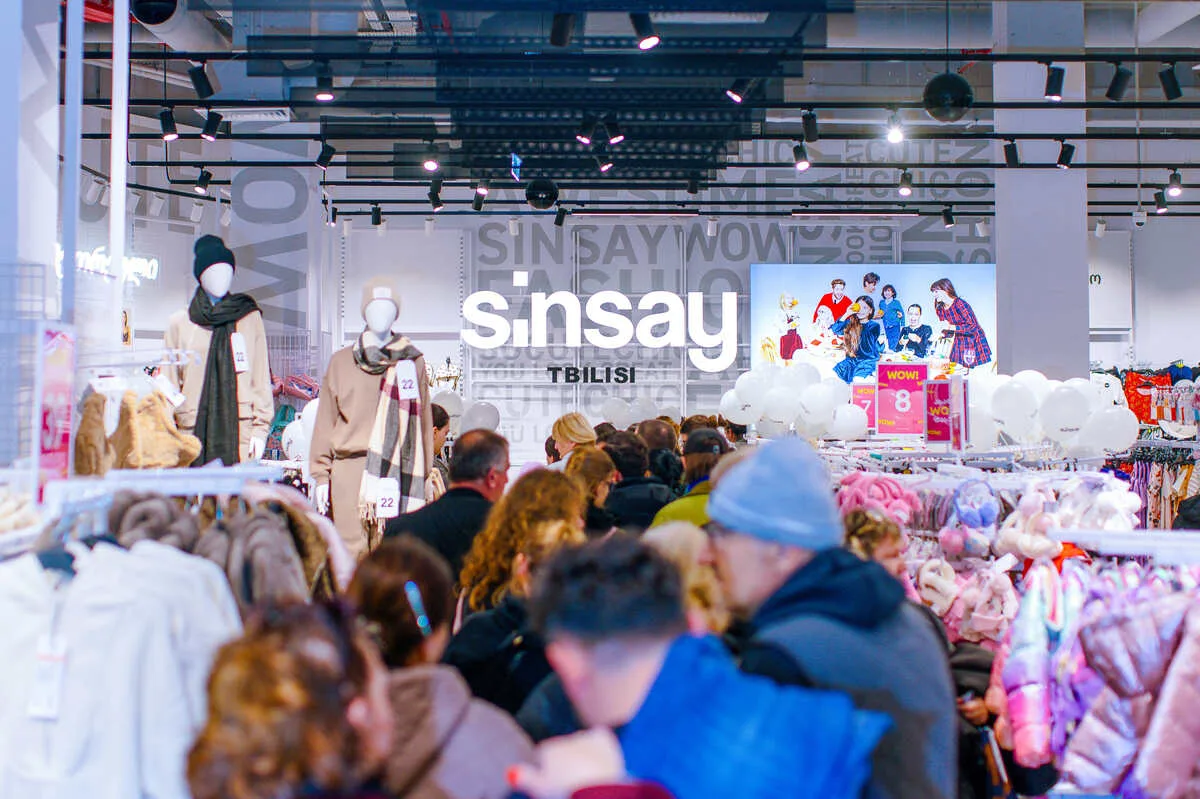 Sklep Sinsay z tłumem klientów, ilustrujący rosnącą popularność brandu wśród konsumentów. Dynamiczny progres sprzedaży oraz model omnichannel mają znaczący wpływ na rezultaty finansowe LPP w roku 2025. Marka Sinsay stanowi jeden z kluczowych motorów ekspansji całej Grupy.