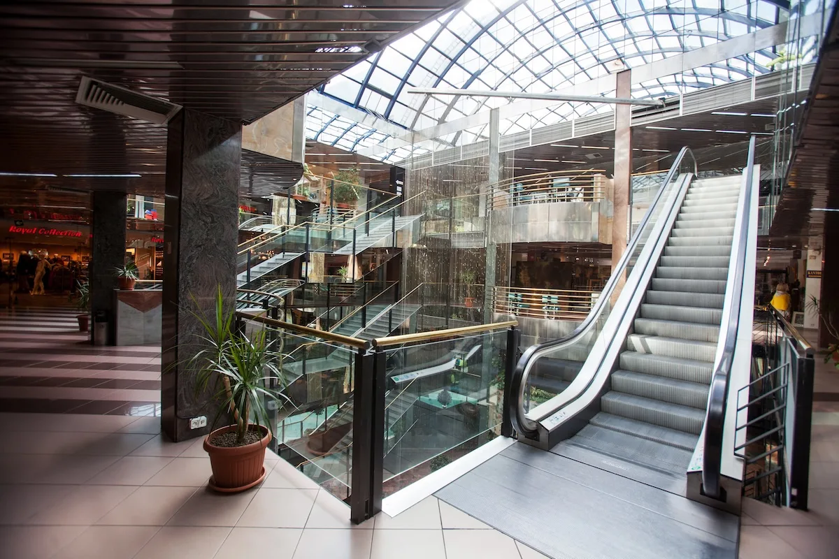 Wnętrze CH Panorama Warszawa – charakterystyczne schody ruchome i przeszklony dach galerii handlowej z lat 90.