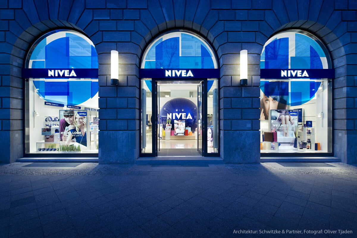 Współczesny lokal handlowy Nivea z charakterystyczną błękitną identyfikacją wizualną oraz prezentacją produktów w oknie wystawowym. Zdjęcie symbolizuje potentata branży kosmetycznej, który znalazł się pod obserwacją regulatora w kontekście spóźnionych rozliczeń z partnerami biznesowymi.
