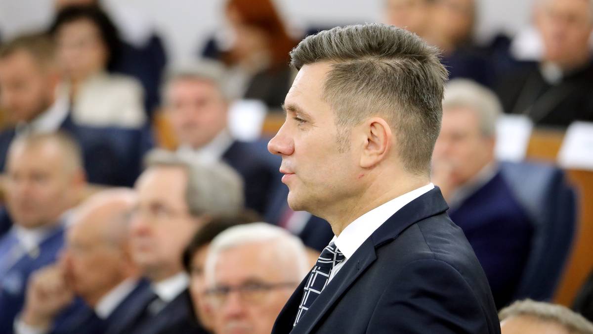 Senator Jacek Włosowicz w garniturze podczas publicznego wystąpienia.