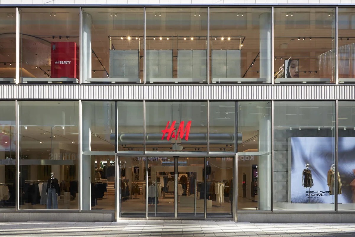 Wyniki finansowe H&amp;M 2025. Nowoczesny sklep H&amp;M Group z okazałymi oknami wystawowymi i przestrzenią handlową. Rezultaty finansowe H&amp;M za rok 2025 demonstrują, że inwestycje w doświadczenie konsumenta oraz sprawność działalności przekładają się na wyższe rentowności pomimo obniżenia obrotów.