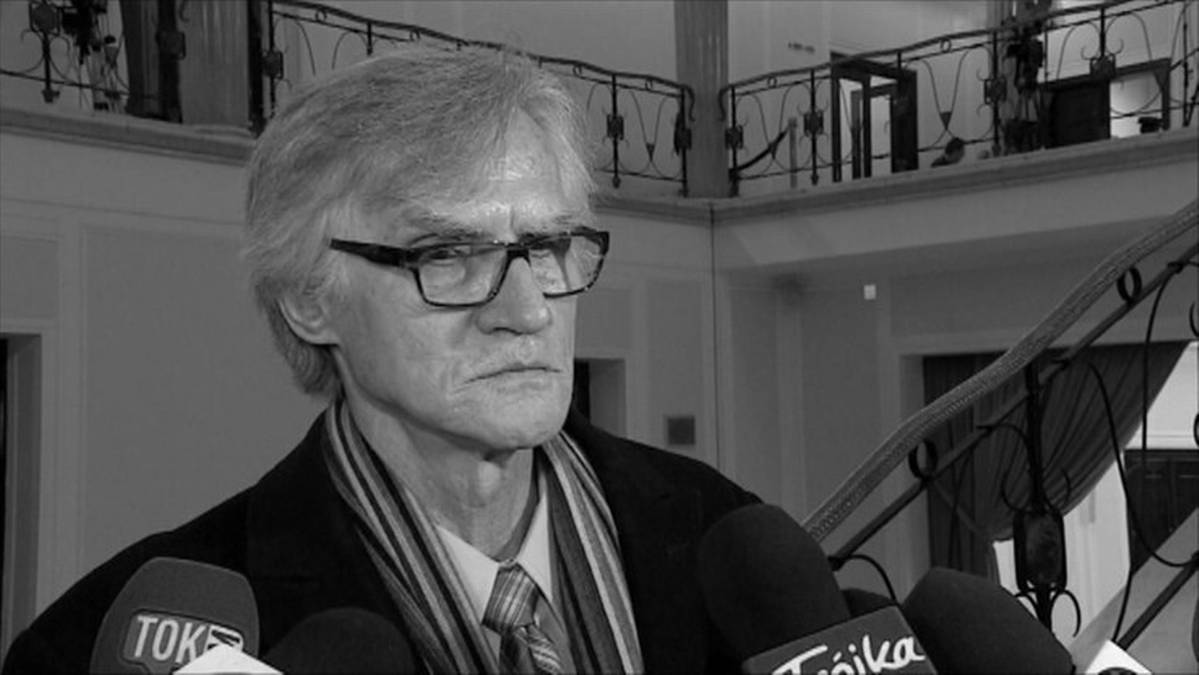 Portret dr. Kazimierza Nowaczyka, fizyka, przed grupą mikrofonów.