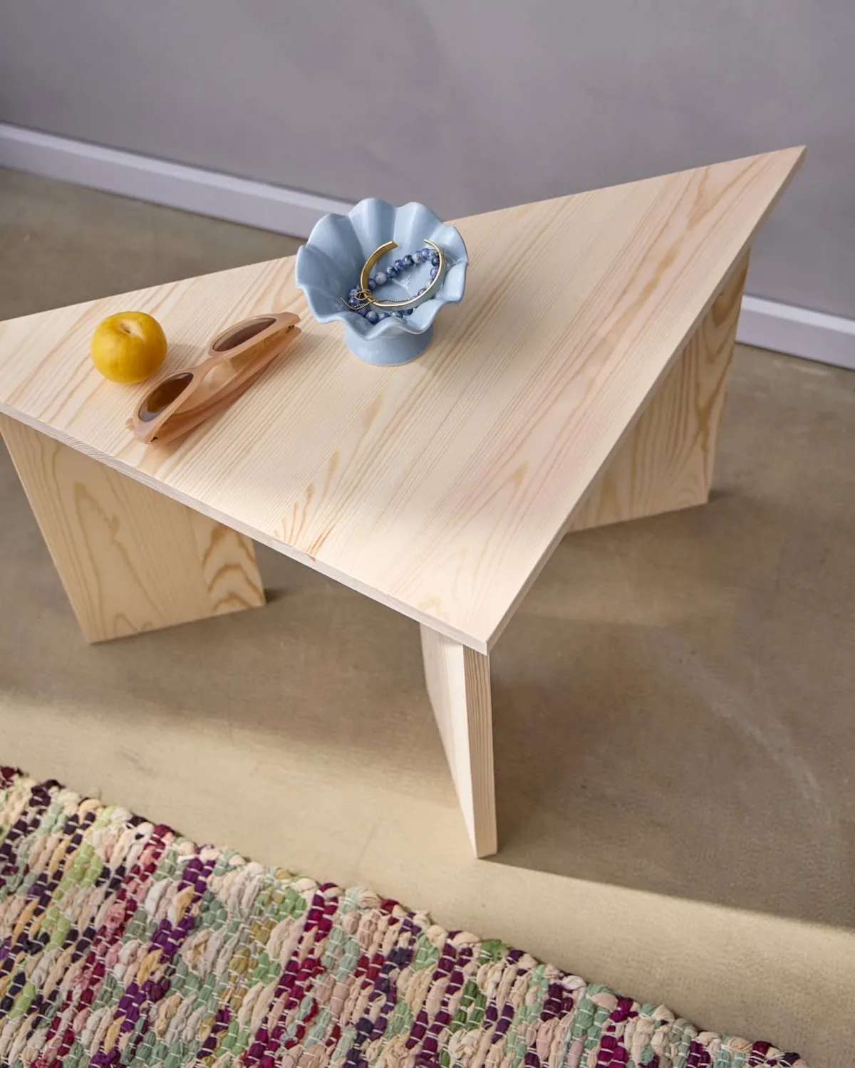 Minimalistyczny drewniany stoliczek z dekoracjami i akcesoriami DIY w stylu Søstrene Grene. Przykład skandynawskiego designu i produktów dostępnych w sklepie online marki.