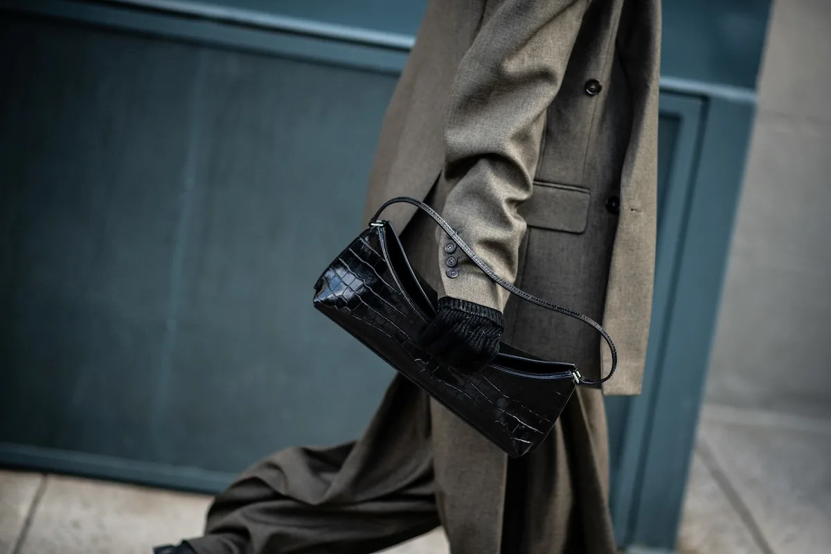 Detal stylizacji – elegancka torebka i klasyczny płaszcz w stonowanych kolorach podkreślają ponadczasową modę uliczną. W przyszłości nawet takie drobne zakupy online mogą być droższe ze względu na nową opłatę manipulacyjną wprowadzaną przez Unię Europejską.