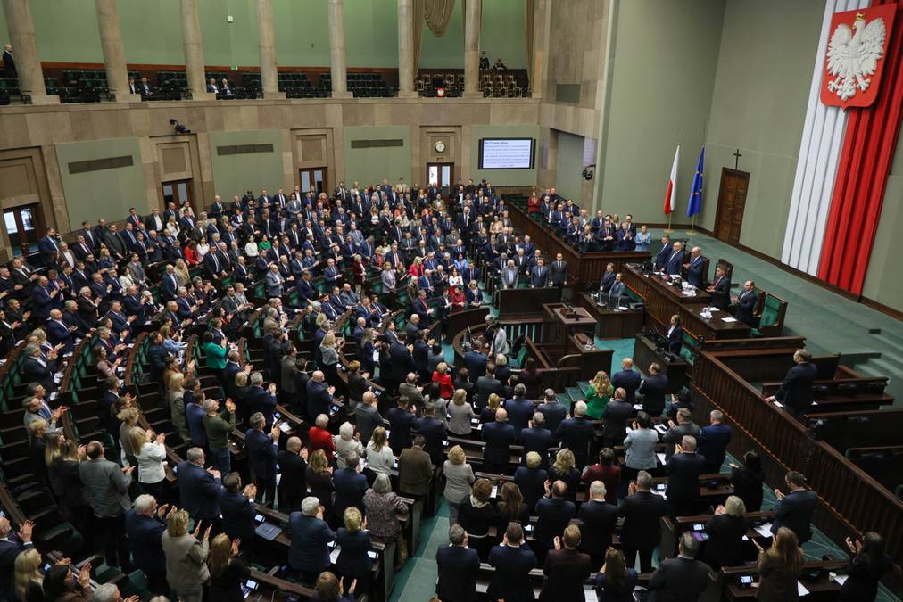 Posiedzenie Sejmu Rzeczypospolitej Polskiej, widok z g&oacute;ry na salę plenarną wypełnioną posłami siedzącymi w ławach.