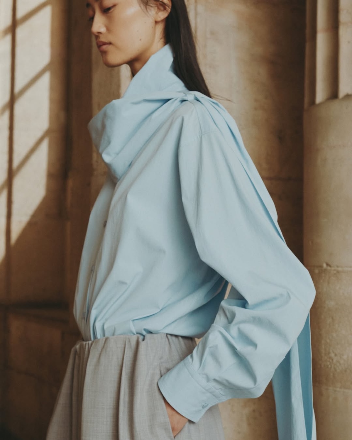 Modelka w błękitnej koszuli Icicle – minimalistyczna estetyka i nacisk na jakość współgrające ze strategią „True Luxury” Kering.
