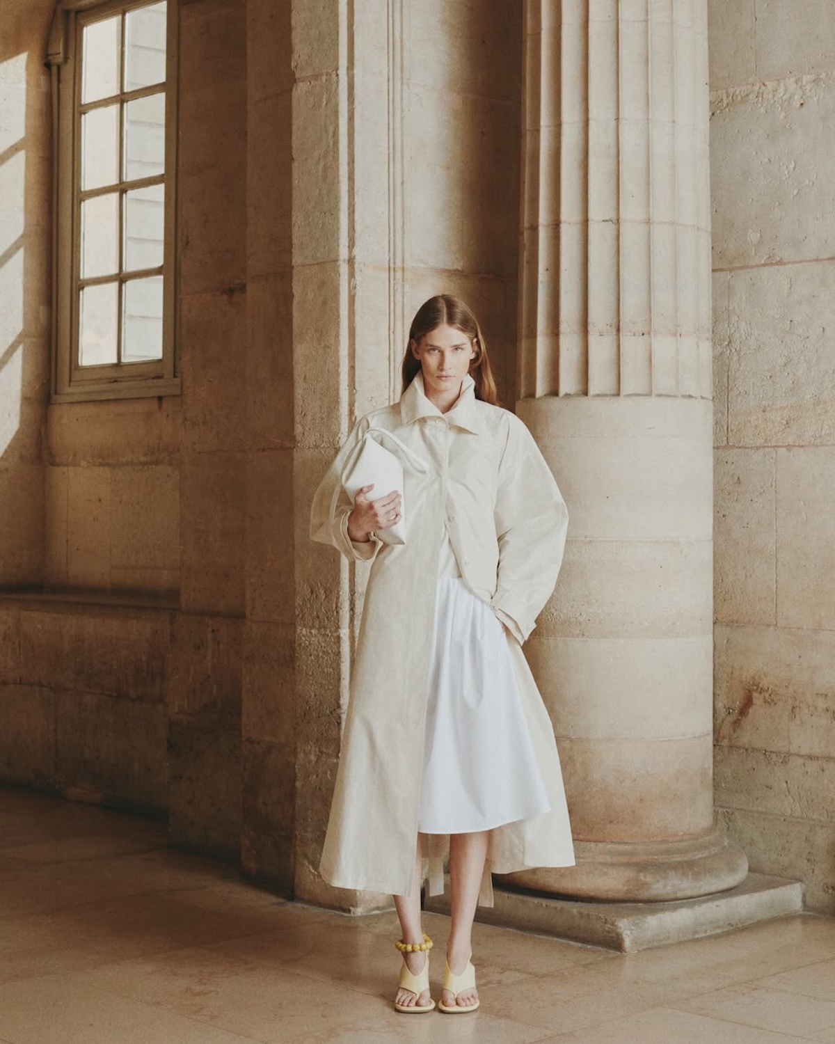 Total look Icicle w neutralnej palecie na tle klasycznej architektury – egzemplifikacja marki łączącej azjatycką tożsamość z globalnym luksusem w strategii Kering.