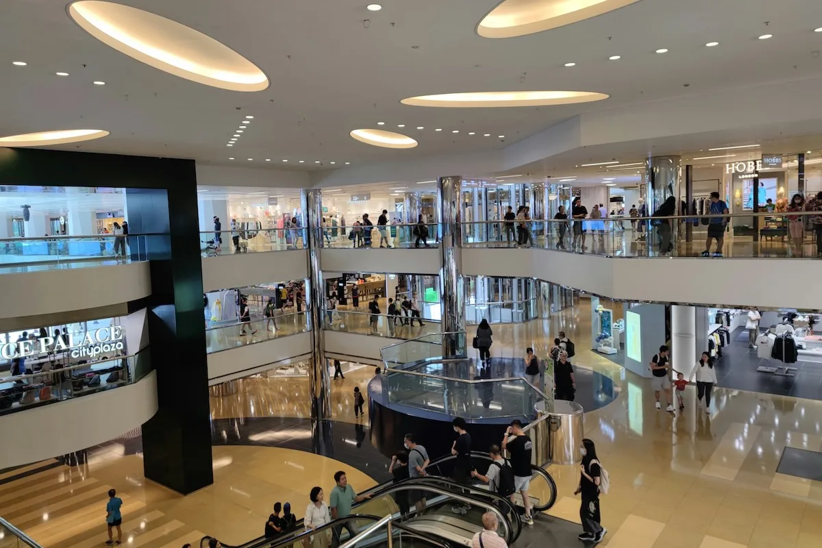 Wnętrze nowoczesnej galerii handlowej z zamkniętymi lub pustymi sklepami, symbolizujące ograniczone godziny handlu w Wielką Sobotę