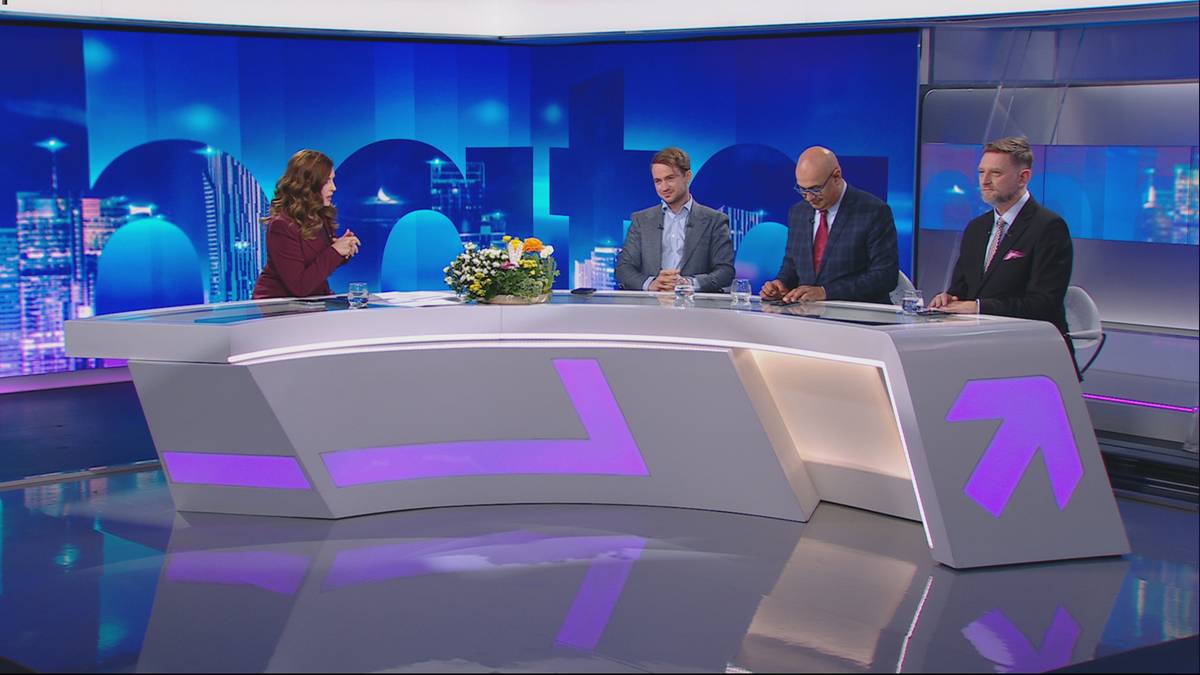 Trzy osoby siedzą przy nowoczesnym, białym stole z fioletowymi elementami graficznymi, w tle znajduje się niebieskie studio telewizyjne z grafikami miasta.