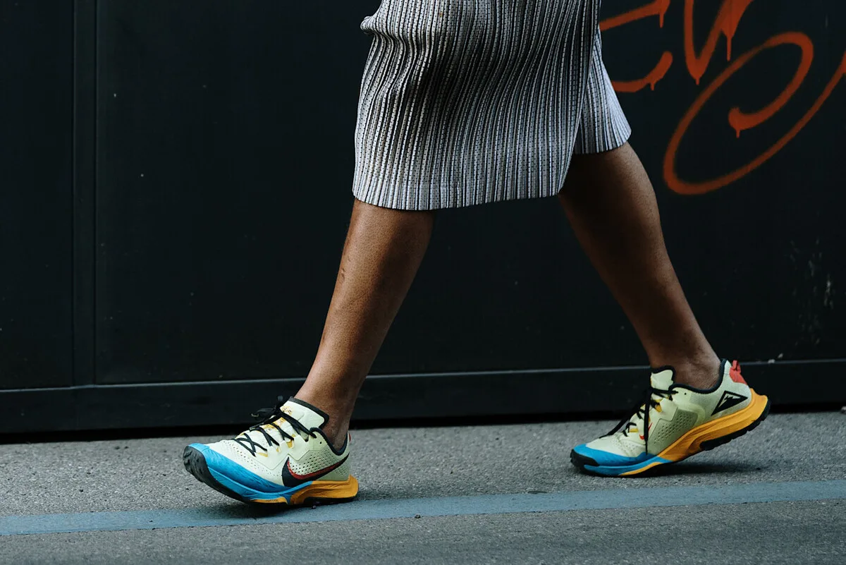 Osoba w obuwiu sportowym od Nike pędzi przez miasto, ukazując model biegowy w ruchu. Obniżka wartości akcji Nike w 2026 roku kontrastuje z energicznym charakterem towarów, które przez lata wspierały rozwój firmy.