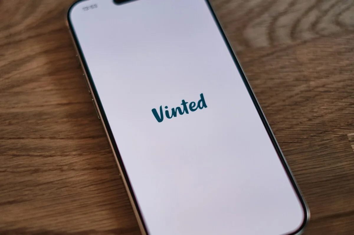 Smartfon z widoczną aplikacją Vinted na ekranie, ilustrujący rosnącą popularność platformy odsprzedaży. Fotografia odnosi się do tematu wyniki finansowe Vinted 2025, które ukazują dynamiczny postęp aplikacji i powiększanie się liczby użytkowników.