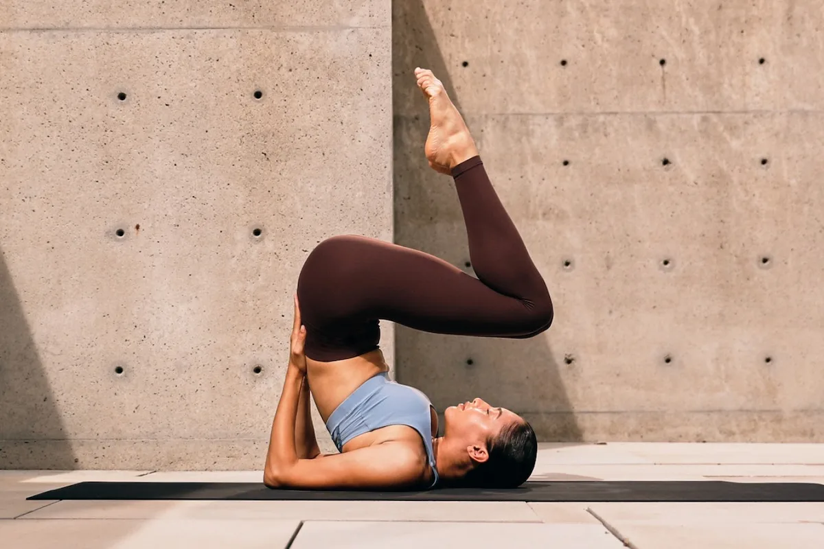 Kobieta uprawiająca jogę w stroju od Lululemon.